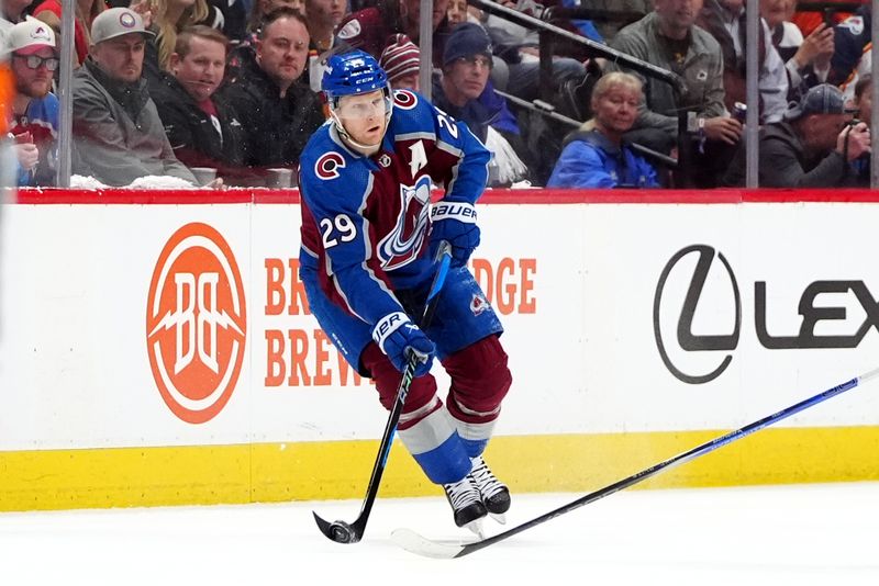 Apr 28, 2024; Denver, Colorado, USA; Colorado Avalanche center Nathan MacKinnon (29) passes the puck during the first period against the Colorado Avalanche in game four of the first round of the 2024 Stanley Cup Playoffs at Ball Arena. Mandatory Credit: Ron Chenoy-USA TODAY Sports