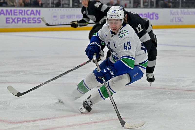 Nov 29, 2025; Los Angeles, California, USA; Vancouver Canucks defenseman Quinn Hughes (43) is pressured by Los Angeles Kings left wing Trevor Moore (12) during the second period at Crypto.com Arena. Mandatory Credit: Jayne Kamin-Oncea-Imagn Images