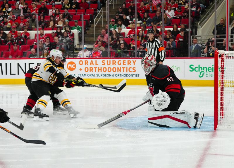 Oct 31, 2024; Raleigh, North Carolina, USA;  Carolina Hurricanes goaltender Pyotr Kochetkov (52) stops the scoring attempt by Boston Bruins left wing Brad Marchand (63) during the second period at Lenovo Center. Mandatory Credit: James Guillory-Imagn Images