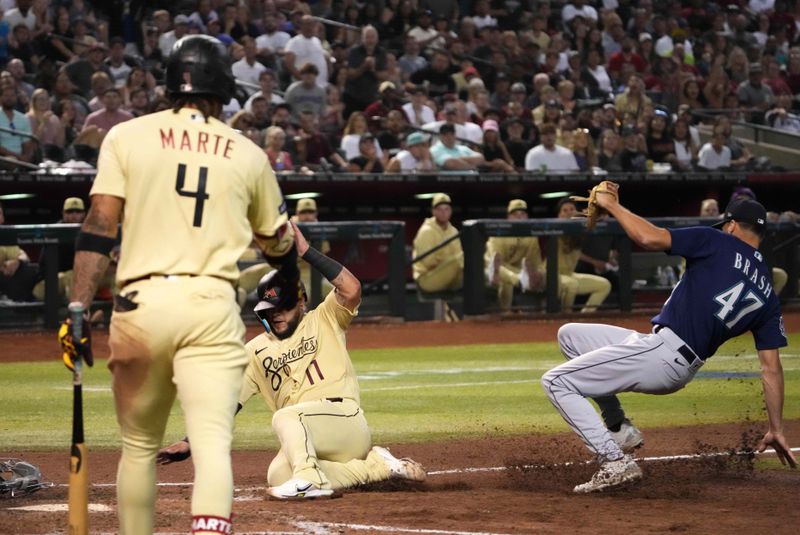 Jul 28, 2023; Phoenix, Arizona, USA; Arizona Diamondbacks second baseman Ketel Marte (4) watches as Arizona Diamondbacks catcher Jose Herrera (11) beats a throw to Seattle Mariners relief pitcher Matt Brash (47) to score a run  during the seventh inning at Chase Field. Mandatory Credit: Joe Camporeale-USA TODAY Sports