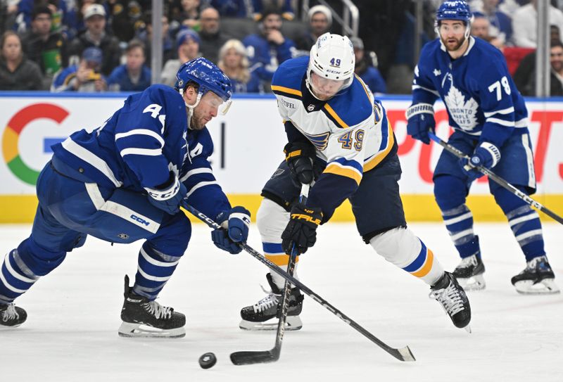 Jan 3, 2023; Toronto, Ontario, CAN; St. Louis Blues forward Ivan Barbashev (49) tries to get past Toronto Maple Leafs defenseman Morgan Rielly (44) in the second period at Scotiabank Arena. Mandatory Credit: Dan Hamilton-USA TODAY Sports