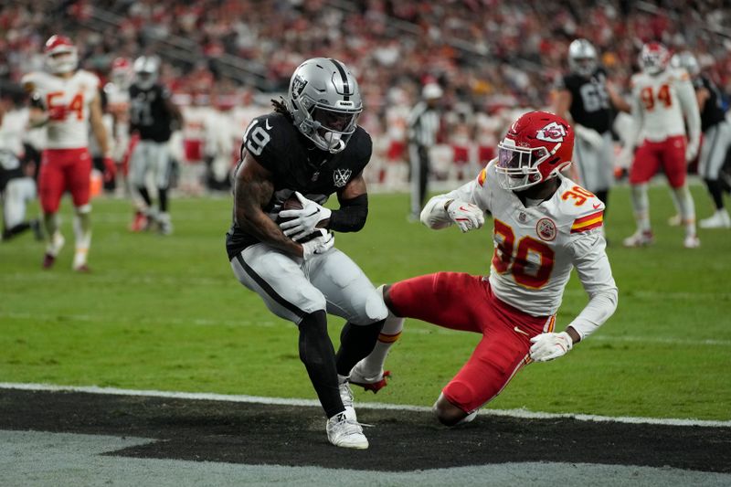 Las Vegas Raiders wide receiver DJ Turner (19) catches a touchdown pass as Kansas City Chiefs cornerback Christian Roland-Wallace (30) defends during the second half of an NFL football game Sunday, Oct. 27, 2024, in Las Vegas. (AP Photo/John Locher)