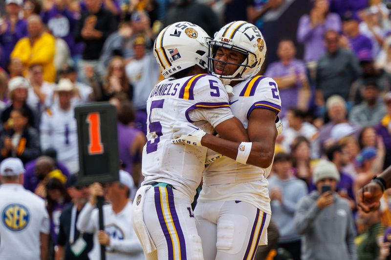 Nov 25, 2023; Baton Rouge, Louisiana, USA;  LSU Tigers quarterback Jayden Daniels (5) hugs  wide receiver Kyren Lacy (2) after he scored a touchdown against the Texas A&M Aggies during the second half at Tiger Stadium. Mandatory Credit: Stephen Lew-USA TODAY Sports