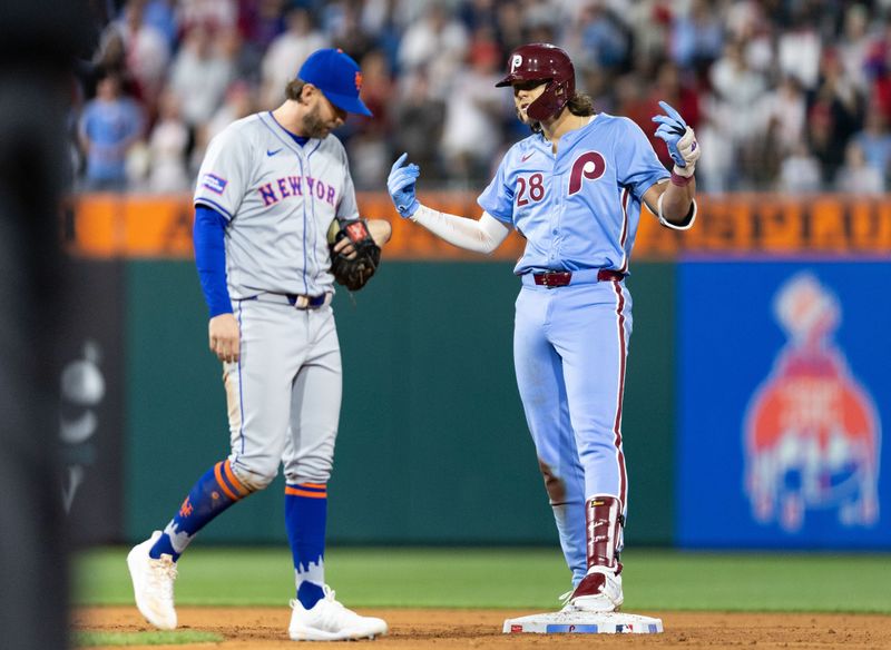 May 16, 2024; Philadelphia, Pennsylvania, USA; Philadelphia Phillies third base Alec Bohm (28) reacts in front of New York Mets second base Jeff McNeil (1) after his RBI single during the sixth inning at Citizens Bank Park. Mandatory Credit: Bill Streicher-USA TODAY Sports