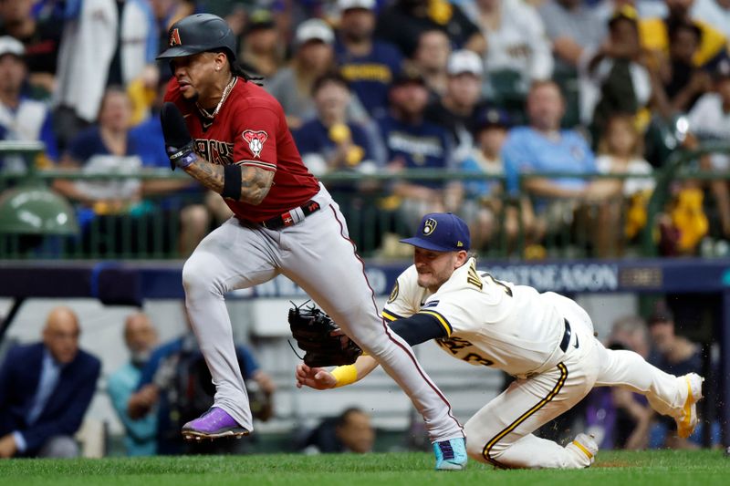 Oct 4, 2023; Milwaukee, Wisconsin, USA; Milwaukee Brewers third baseman Josh Donaldson (3) attempts to tag Arizona Diamondbacks second baseman Ketel Marte (4) in the sixth inning during game two of the Wildcard series for the 2023 MLB playoffs at American Family Field. Mandatory Credit: Kamil Krzaczynski-USA TODAY Sports