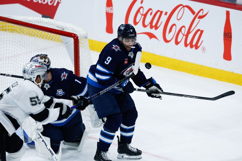 Jan 9, 2026; Winnipeg, Manitoba, CAN; Winnipeg Jets forward Alex Iafallo (9) and Los Angeles Kings forward Quinton Byfield (55) contest for the puck during the third period at Canada Life Centre. Mandatory Credit: Terrence Lee-Imagn Images