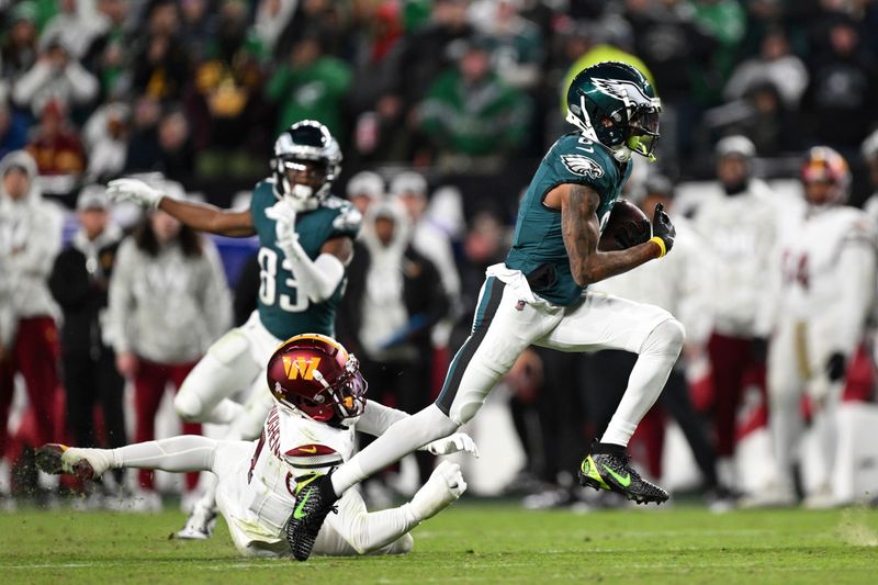 Philadelphia Eagles wide receiver DeVonta Smith runs with the ball after catching a pass against Washington Commanders cornerback Noah Igbinoghene during the first half of an NFL football game, Thursday, Nov. 14, 2024, in, Philadelphia. (AP Photo/Terrance Williams)