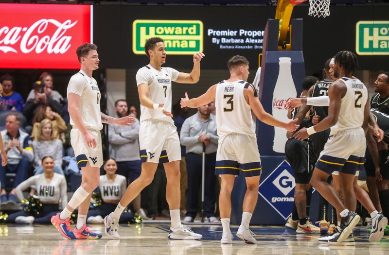 Feb 20, 2024; Morgantown, West Virginia, USA; West Virginia Mountaineers center Jesse Edwards (7) celebrates with teammates during the first half against the UCF Knights at WVU Coliseum. Mandatory Credit: Ben Queen-USA TODAY Sports