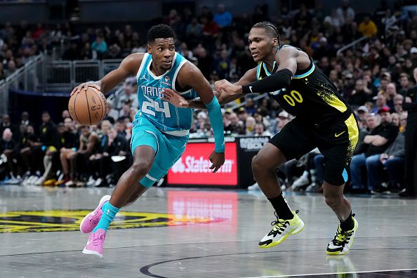 INDIANAPOLIS, INDIANA - DECEMBER 20: Brandon Miller #24 of the Charlotte Hornets dribbles the ball while being guarded by Bennedict Mathurin #00 of the Indiana Pacers in the fourth quarter at Gainbridge Fieldhouse on December 20, 2023 in Indianapolis, Indiana. NOTE TO USER: User expressly acknowledges and agrees that, by downloading and or using this photograph, User is consenting to the terms and conditions of the Getty Images License Agreement. (Photo by Dylan Buell/Getty Images)