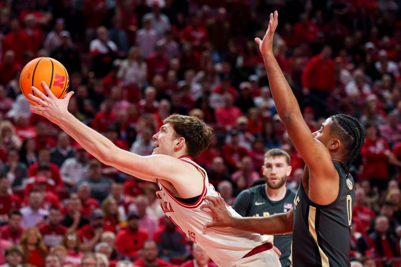 Feb 10, 2026; Lincoln, Nebraska, USA; Nebraska Cornhuskers forward Pryce Sandfort (21) reaches for the ball against Purdue Boilermakers guard C.J. Cox (0) during the first half at Pinnacle Bank Arena. Mandatory Credit: Dylan Widger-Imagn Images