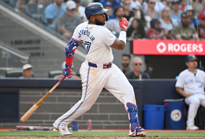 Sep 14, 2024; Toronto, Ontario, CAN;  Toronto Blue Jays first baseman Vladimir Guerrero Jr. (27) hits an RBI single against the St. Louis Cardinals in the seventh inning at Rogers Centre. It was the 500th RBI of his career. Mandatory Credit: Dan Hamilton-Imagn Images