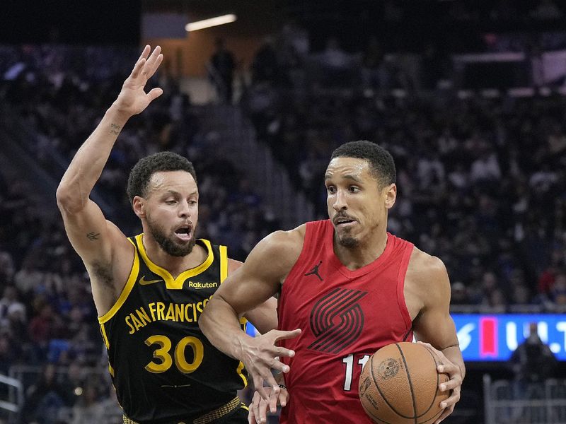 SAN FRANCISCO, CALIFORNIA - DECEMBER 23: Malcolm Brogdon #11 of the Portland Trail Blazers drives towards the basket on Stephen Curry #30 of the Golden State Warriors during the first half at Chase Center on December 23, 2023 in San Francisco, California. NOTE TO USER: User expressly acknowledges and agrees that, by downloading and or using this photograph, User is consenting to the terms and conditions of the Getty Images License Agreement. (Photo by Thearon W. Henderson/Getty Images)