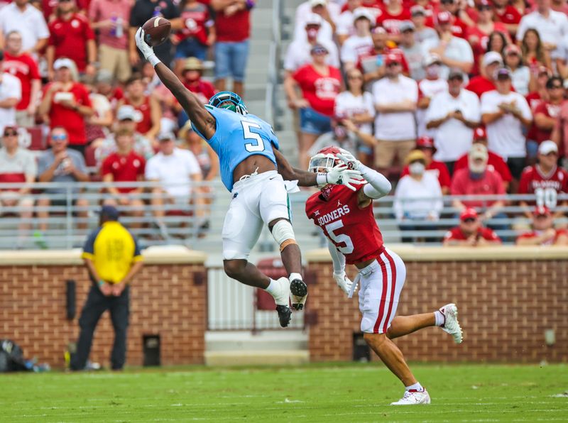 Sep 4, 2021; Norman, Oklahoma, USA;  Tulane Green Wave running back Ygenio Booker (5) makes a one handed leaping catchin fron tof Oklahoma Sooners defensive back Billy Bowman (5) during the first quarter at Gaylord Family-Oklahoma Memorial Stadium. Mandatory Credit: Kevin Jairaj-USA TODAY Sports