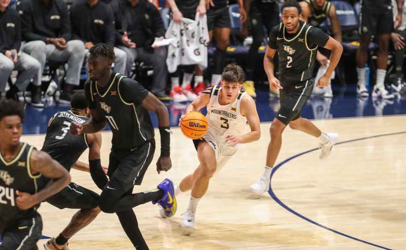 Feb 20, 2024; Morgantown, West Virginia, USA; West Virginia Mountaineers guard Kerr Kriisa (3) dribbles the ball during the second half against the UCF Knights at WVU Coliseum. Mandatory Credit: Ben Queen-USA TODAY Sports