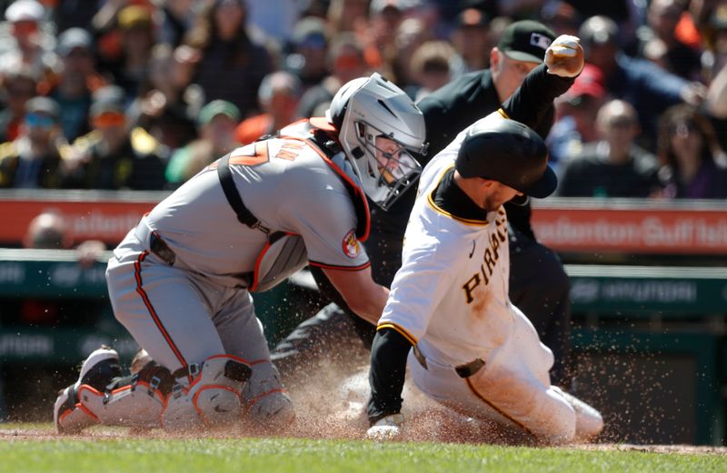 Apr 7, 2024; Pittsburgh, Pennsylvania, USA;  Baltimore Orioles catcher James McCann (27) tags Pittsburgh Pirates second baseman Jared Triolo (19) out at home plate attempting to score during the third inning  at PNC Park. Mandatory Credit: Charles LeClaire-USA TODAY Sports