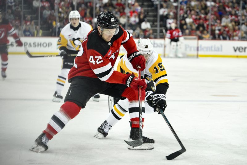 Apr 2, 2024; Newark, New Jersey, USA; New Jersey Devils center Curtis Lazar (42) skates with the puck while being defended by Pittsburgh Penguins right wing Reilly Smith (19) during the second period at Prudential Center. Mandatory Credit: John Jones-USA TODAY Sports