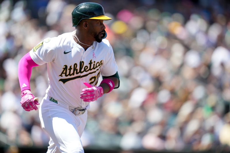 May 11, 2025; West Sacramento, California, USA; Athletics right fielder Miguel Andujar (22) runs towards first base after hitting an RBI single against the New York Yankees in the fourth inning at Sutter Health Park. Mandatory Credit: Cary Edmondson-Imagn Images
