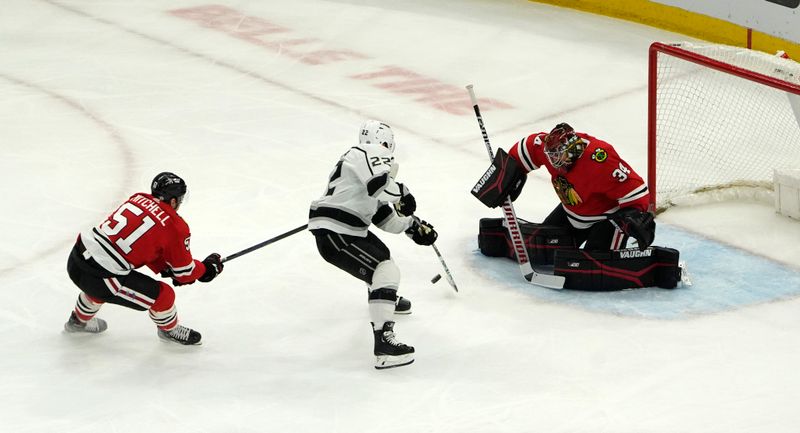 Jan 22, 2023; Chicago, Illinois, USA; Los Angeles Kings left wing Kevin Fiala (22) skates in on Chicago Blackhawks goaltender Petr Mrazek (34) as defenseman Ian Mitchell (51) defends during the first period at United Center. Mandatory Credit: David Banks-USA TODAY Sports