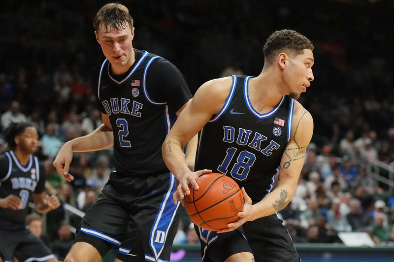 Feb 25, 2025; Coral Gables, Florida, USA;  Duke Blue Devils forward Mason Gillis (18) grabs a rebound as guard Cooper Flagg (2) follows on the play during the second half at Watsco Center. Mandatory Credit: Jim Rassol-Imagn Images