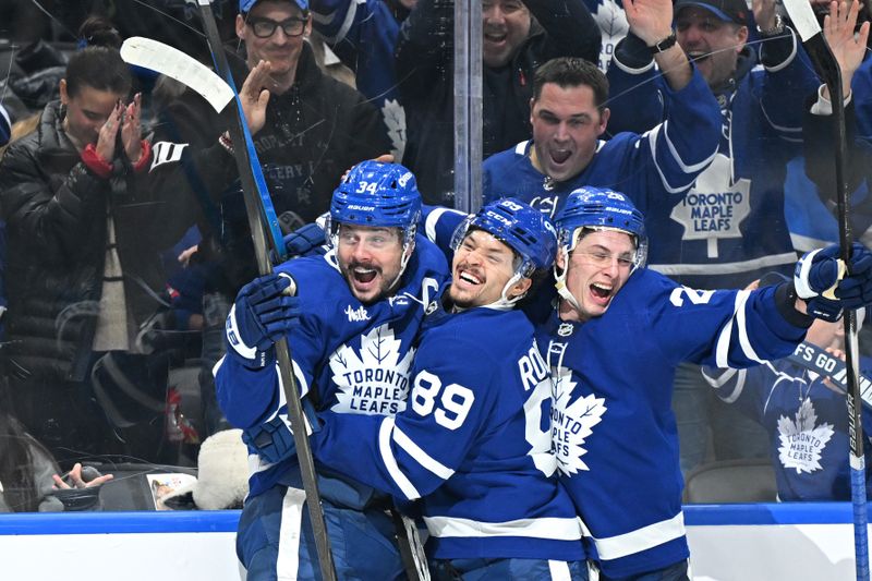 Jan 1, 2026; Toronto, Ontario, CAN;  Toronto Maple Leafs forward Auston Matthews (34) celebrates with forward Nick Robertson (89) and defenseman Troy Stecher (28) after scoring his third goal of the game against the Winnipeg Jets in the third period at Scotiabank Arena. Mandatory Credit: Dan Hamilton-Imagn Images