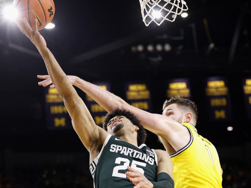 Feb 18, 2023; Ann Arbor, Michigan, USA;  Michigan State Spartans forward Malik Hall (25) shoots the ball against Michigan Wolverines center Hunter Dickinson (1) in the second half at Crisler Center. Mandatory Credit: Rick Osentoski-USA TODAY Sports