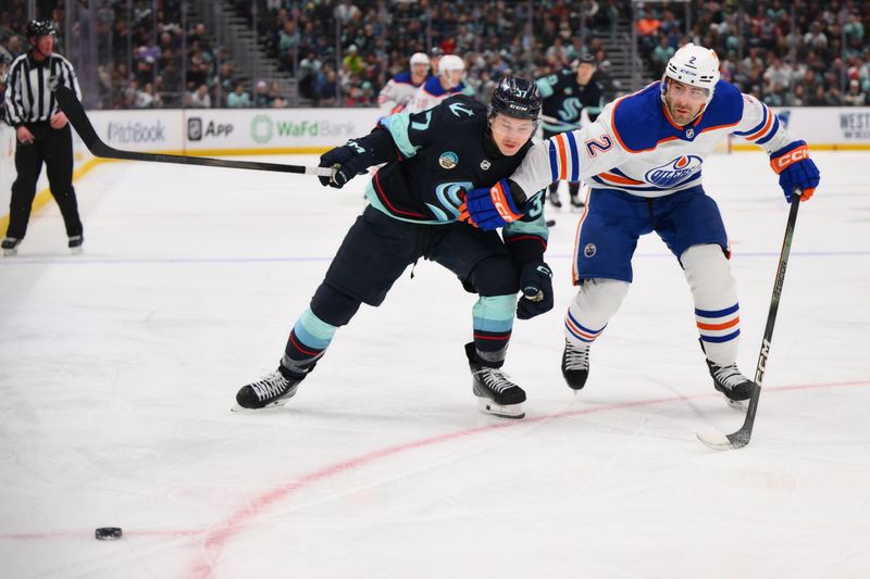 Mar 2, 2024; Seattle, Washington, USA; Seattle Kraken center Yanni Gourde (37) and Edmonton Oilers defenseman Evan Bouchard (2) chase the puck during the second period at Climate Pledge Arena. Mandatory Credit: Steven Bisig-USA TODAY Sports