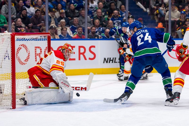 Apr 16, 2024; Vancouver, British Columbia, CAN; Calgary Flames goalie Jacob Markstrom (25) makes a save on Vancouver Canucks forward Pius Suter (24) in the first period at Rogers Arena. Mandatory Credit: Bob Frid-USA TODAY Sports