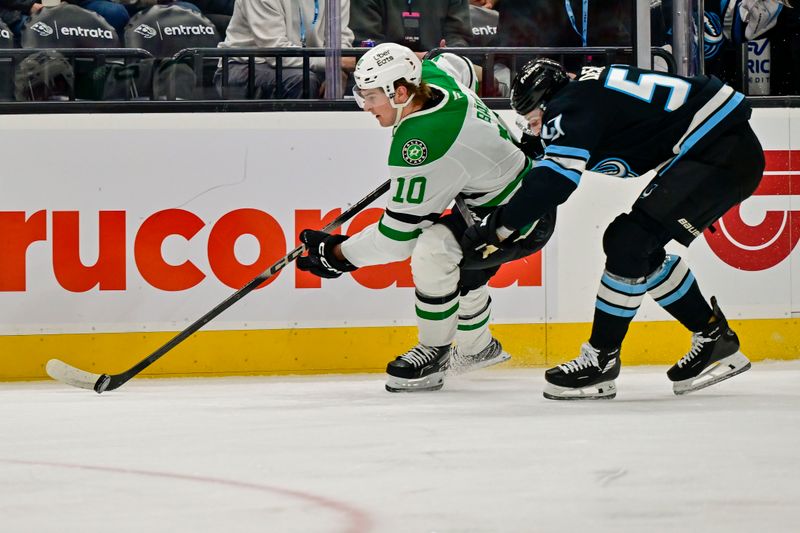 Jan 31, 2026; Salt Lake City, Utah, USA; Dallas Stars center Oskar Bäck (10) holds off Utah Mammoth defenseman Nick DeSimone (57) during first period at Delta Center. Mandatory Credit: Peter Creveling-Imagn Images