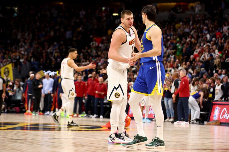 DENVER, COLORADO - DECEMBER 25: Nikola Jokic #15 of the Denver Nuggets and Dario Saric #20 of the Golden State Warriors shake hands at Ball Arena on December 25, 2023 in Denver, Colorado. NOTE TO USER: User expressly acknowledges and agrees that, by downloading and/or using this Photograph, user is consenting to the terms and conditions of the Getty Images License Agreement. (Photo by Jamie Schwaberow/Getty Images)