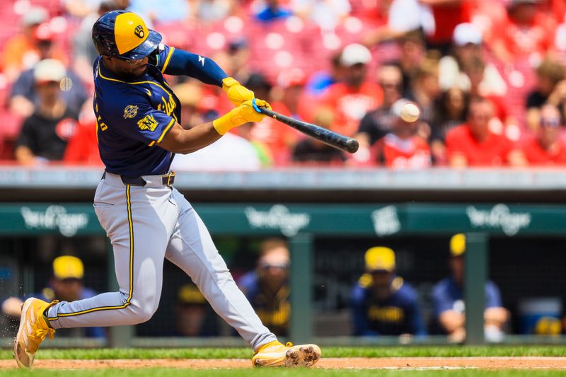 Jun 4, 2025; Cincinnati, Ohio, USA; Milwaukee Brewers third baseman Andruw Monasterio (14) hits a RBI single in the third inning against the Cincinnati Reds at Great American Ball Park. Mandatory Credit: Katie Stratman-Imagn Images