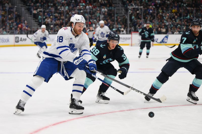 Jan 21, 2024; Seattle, Washington, USA; Toronto Maple Leafs center Noah Gregor (18) plays the puck while defended by Seattle Kraken defenseman Ryker Evans (39) during the third period at Climate Pledge Arena. Mandatory Credit: Steven Bisig-USA TODAY Sports