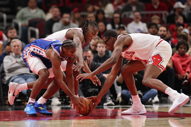 CHICAGO, ILLINOIS - DECEMBER 08: Tyrese Maxey #0 of the Philadelphia 76ers battles with Ayo Dosunmu #11 and Jalen Smith #7 of the Chicago Bulls for a loose ball during the second half at the United Center on December 08, 2024 in Chicago, Illinois. NOTE TO USER: User expressly acknowledges and agrees that, by downloading and or using this photograph, User is consenting to the terms and conditions of the Getty Images License Agreement.  (Photo by Michael Reaves/Getty Images)