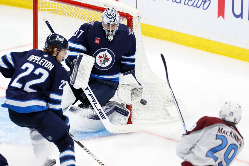 Apr 30, 2024; Winnipeg, Manitoba, CAN; Colorado Avalanche center Nathan MacKinnon (29) shoots on Winnipeg Jets goaltender Connor Hellebuyck (37) in the third period in game five of the first round of the 2024 Stanley Cup Playoffs at Canada Life Centre. Mandatory Credit: James Carey Lauder-USA TODAY Sports