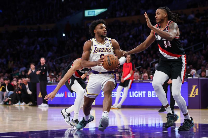 LOS ANGELES, CALIFORNIA - DECEMBER 08: Bronny James #9 of the Los Angeles Lakers drives with the ball against Jabari Walker #34 of the Portland Trail Blazers in the second half at Crypto.com Arena on December 08, 2024 in Los Angeles, California. NOTE TO USER: User expressly acknowledges and agrees that, by downloading and or using this Photograph, user is consenting to the terms and conditions of the Getty Images License Agreement. (Photo by Meg Oliphant/Getty Images)