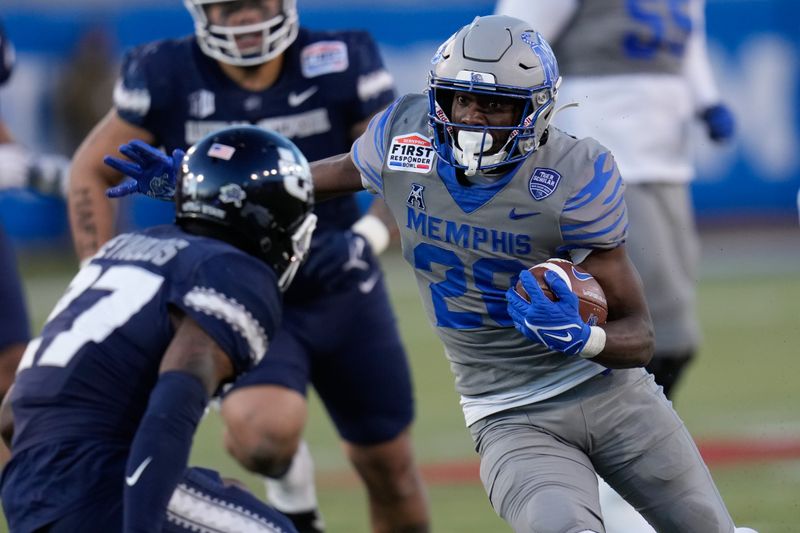 Dec 27, 2022; Dallas, Texas, USA; Memphis Tigers running back Asa Martin (28) runs the ball against Utah State Aggies safety Hunter Reynolds (27) during the second half in the 2022 First Responder Bowl at Gerald J. Ford Stadium. Mandatory Credit: Chris Jones-USA TODAY Sports