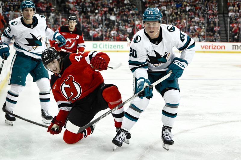 Nov 10, 2024; Newark, New Jersey, USA; New Jersey Devils defenseman Luke Hughes (43) and San Jose Sharks left wing Fabian Zetterlund (20) compete for the puck during the third period at Prudential Center. Mandatory Credit: John Jones-Imagn Images