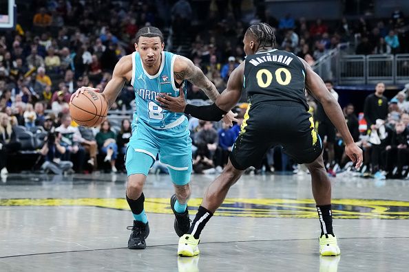 INDIANAPOLIS, INDIANA - DECEMBER 20: Nick Smith Jr. #8 of the Charlotte Hornets dribbles the ball while being guarded by Bennedict Mathurin #00 of the Indiana Pacers in the fourth quarter at Gainbridge Fieldhouse on December 20, 2023 in Indianapolis, Indiana. NOTE TO USER: User expressly acknowledges and agrees that, by downloading and or using this photograph, User is consenting to the terms and conditions of the Getty Images License Agreement. (Photo by Dylan Buell/Getty Images)