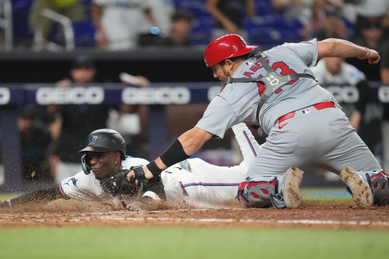 Jun 17, 2024; Miami, Florida, USA;  St. Louis Cardinals catcher Pedro Pagés (43) tags out Miami Marlins left fielder Nick Gordon (1) at home plate in the 12th inning at loanDepot Park. Mandatory Credit: Jim Rassol-USA TODAY Sports