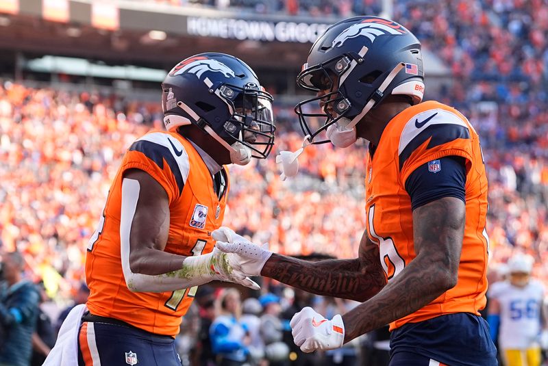 Denver Broncos wide receiver Courtland Sutton (14), left, celebrates with wide receiver Troy Franklin (16) after catching a 15-yard touchdown pass during the second half of an NFL football game against the Los Angeles Chargers, Sunday, Oct. 13, 2024, in Denver. (AP Photo/David Zalubowski)