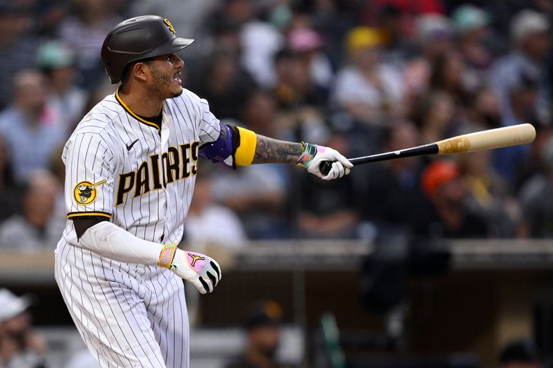 Aug 21, 2023; San Diego, California, USA; San Diego Padres third baseman Manny Machado (13) hits a sacrifice fly against the Miami Marlins during the first inning at Petco Park. Mandatory Credit: Orlando Ramirez-USA TODAY Sports