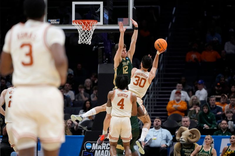 Mar 21, 2024; Charlotte, NC, USA; Texas Longhorns forward Brock Cunningham (30) puts up a shot contested by Colorado State Rams forward Patrick Cartier (12) in the first round of the 2024 NCAA Tournament at Spectrum Center. Mandatory Credit: Bob Donnan-USA TODAY Sports