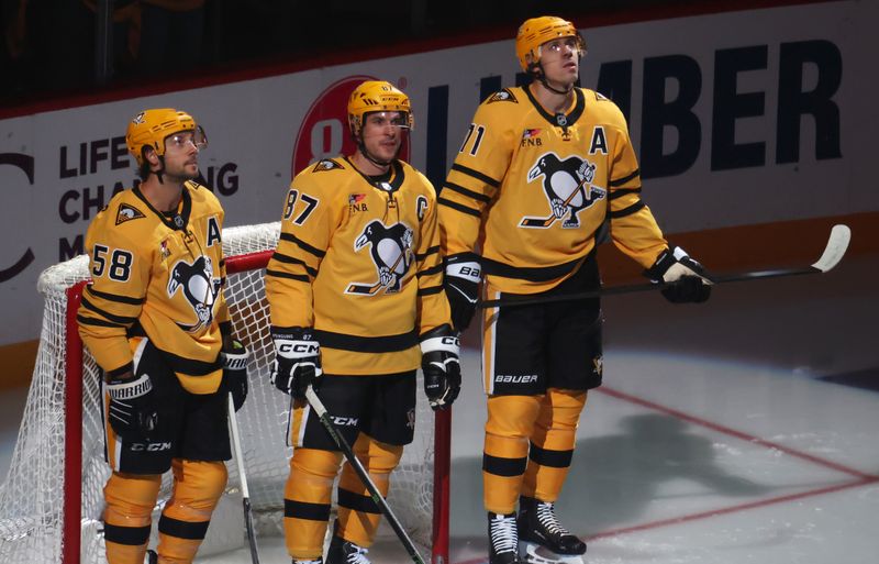 Oct 9, 2025; Pittsburgh, Pennsylvania, USA;  Pittsburgh Penguins defenseman Kris Letang (58) and center Sidney Crosby (87) and center Evgeni Malkin (71) stand as they are recognized as the longest tenured teammates in North American professional sports history before their twentieth season together prior to the game against the New York Islanders at PPG Paints Arena. Mandatory Credit: Charles LeClaire-Imagn Images