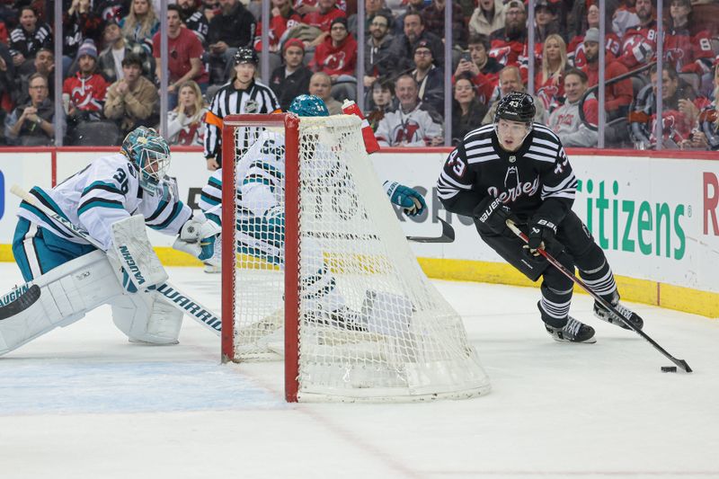 Dec 1, 2023; Newark, New Jersey, USA; New Jersey Devils defenseman Luke Hughes (43) skates with the puck in front of San Jose Sharks goaltender Kaapo Kahkonen (36) pursues during the first period at Prudential Center. Mandatory Credit: Vincent Carchietta-USA TODAY Sports