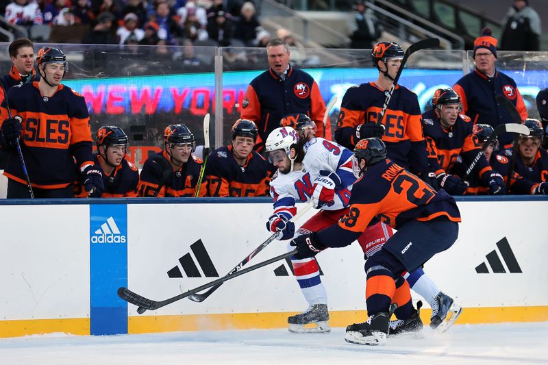 Feb 18, 2024; East Rutherford, New Jersey, USA; New York Rangers center Mika Zibanejad (93) plays the puck against New York Islanders defenseman Alexander Romanov (28) during the first period of a Stadium Series ice hockey game at MetLife Stadium. Mandatory Credit: Brad Penner-USA TODAY Sports