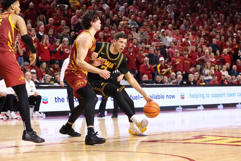 Dec 11, 2025; Ames, Iowa, USA;  Iowa State Cyclones forward Blake Buchanan (23) defends Iowa Hawkeyes forward Alvaro Folgueiras (7) during the second half at James H. Hilton Coliseum. Mandatory Credit: Reese Strickland-Imagn Images