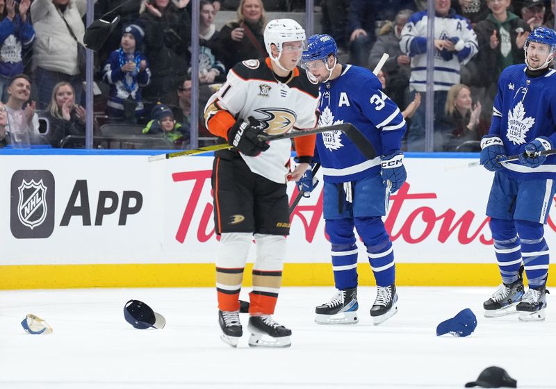 Feb 17, 2024; Toronto, Ontario, CAN; Fans throw hats onto the ice after Toronto Maple Leafs center Auston Matthews (34) scored his third goal against the Anaheim Ducks during the second period at Scotiabank Arena. Mandatory Credit: Nick Turchiaro-USA TODAY Sports