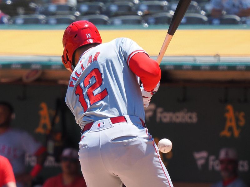 Jul 4, 2024; Oakland, California, USA; Los Angeles Angels center fielder Kevin Pillar (12) avoids the ball to earn a walk against the Oakland Athletics during the third inning at Oakland-Alameda County Coliseum. Mandatory Credit: Kelley L Cox-USA TODAY Sports