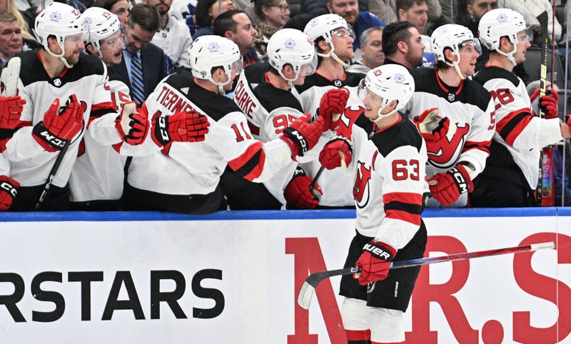 Apr 11, 2024; Toronto, Ontario, CAN; New Jersey Devils forward Jesper Bratt (63) celebrates at the bench with team mates after scoring against the Toronto Maple Leafs in the third period at Scotiabank Arena. Mandatory Credit: Dan Hamilton-USA TODAY Sports