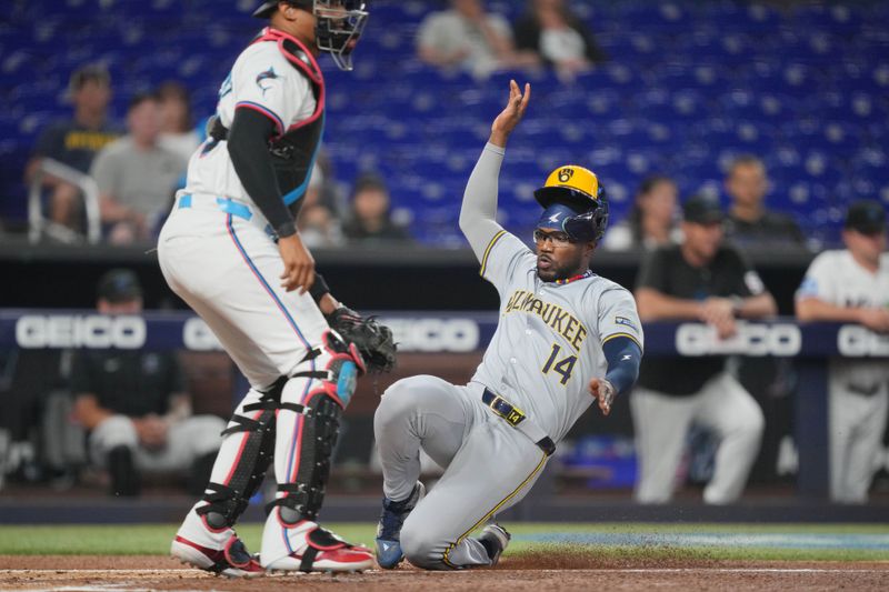 May 21, 2024; Miami, Florida, USA;  Milwaukee Brewers second baseman Andruw Monasterio (14) scores a run in the first inning against the Miami Marlins at loanDepot Park. Mandatory Credit: Jim Rassol-USA TODAY Sports