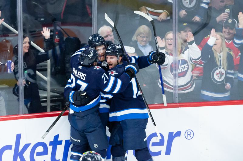 Jan 11, 2024; Winnipeg, Manitoba, CAN; Winnipeg Jets forward Gabriel Vilardi (13) is congratulated by Winnipeg Jets forward Adam Lowry (17) and Winnipeg Jets forward Nikolaj Ehlers (27) on his goal against Chicago Blackhawks goalie Petr Mrazek (34) during the third period at Canada Life Centre. Mandatory Credit: Terrence Lee-USA TODAY Sports